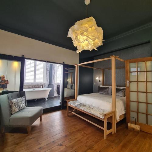 a bedroom with a canopy bed and a bath tub at What’s behind the green door! in Cape Town