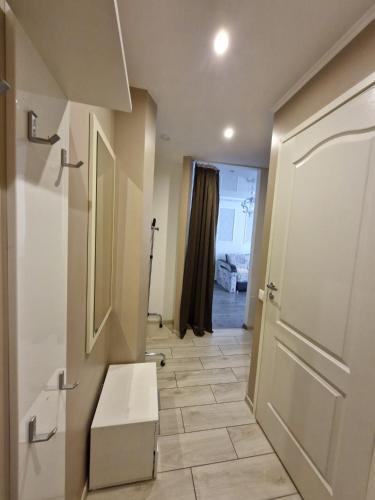 a bathroom with a white door and a tile floor at Tallinna mnt 15 Apartament in Narva