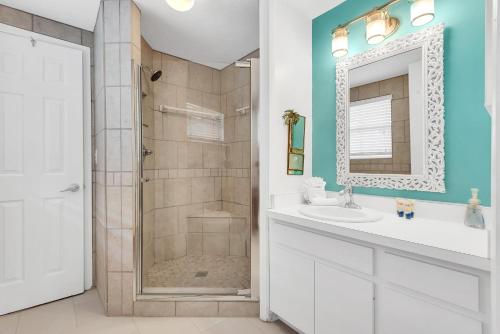 een badkamer met douche, wastafel en spiegel bij Island Sea-Cret in Anna Maria