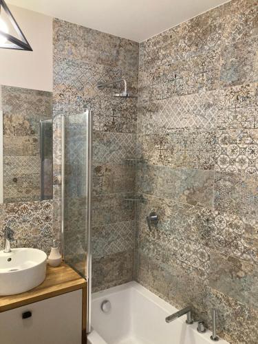 a bathroom with a tub and a sink and a shower at Nowoczesne mieszkanie Yellow in Pogórze