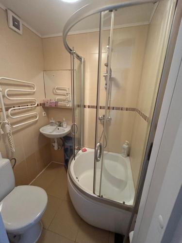 een badkamer met een douche, een toilet en een wastafel bij Butas prie vaikų parko in Ventspils