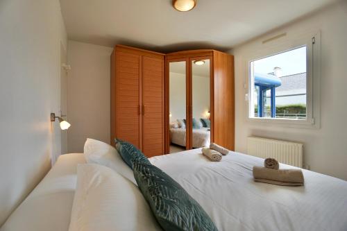 une chambre avec un grand lit blanc avec une fenêtre dans l'établissement Villa Anne - 500m de la mer - SPA, à Moëlan-sur-Mer