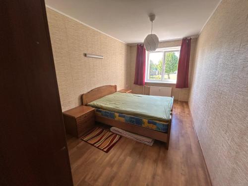 een kleine kamer met een bed en een raam bij Butas prie vaikų parko in Ventspils