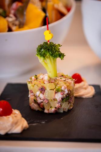 a piece of food with a piece of broccoli on a black plate at Royal Tulip Taj Sultan in Hammamet