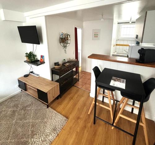 a living room with a counter and a kitchen with a table at Studio Charme Cosy - Proxi CDG & Parc Astérix in Vémars