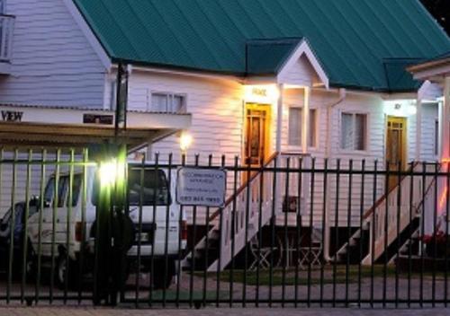 a white house with a car parked in front of it at Knock Out View Clarens in Clarens