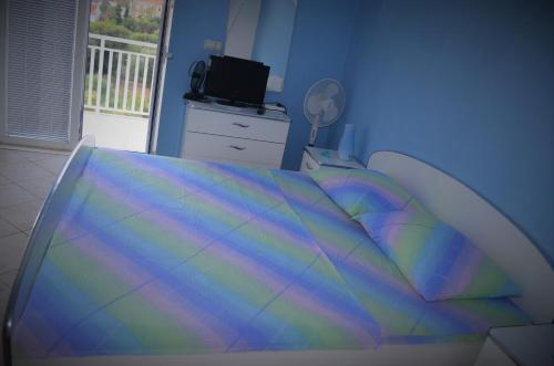 um quarto com uma cama com um cobertor colorido em Apartmants Bubalo em Trpanj