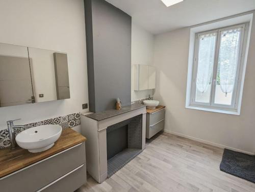 une salle de bain blanche avec un lavabo et un miroir dans l'établissement à 5mn de la réserve Africaine, charmante maison de village avec patio, à Sigean