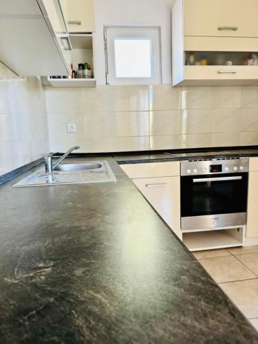 a kitchen with a sink and a stove at Villa Paradisio Ruheoase - Pool - Klima - Küche - Parken in Milna