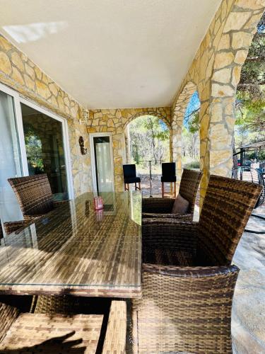 a patio with chairs and a table and a stone wall at Villa Paradisio Ruheoase - Pool - Klima - Küche - Parken in Milna