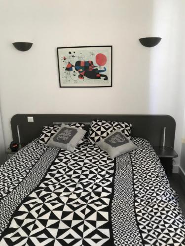 - un lit noir et blanc avec 2 oreillers dans l'établissement Résid Azur, à Saint-Jean-de-Monts