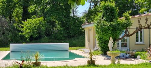 une piscine dans une cour à côté d'une maison dans l'établissement Bergerac Chambre d'hôte oiseaux de paradis, à Bergerac