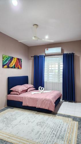 a bedroom with a bed with blue curtains and a window at AZ homestay KLIA in Banting