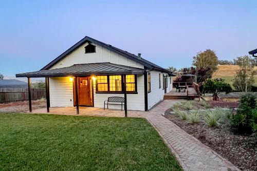 a small white house with a porch and a patio at Penngrove Farmhouse Retreat in Penngrove