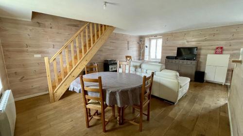 a living room with a table and a staircase at J4 Parking, Wifi Grand 2 Chambres 3 lits 2 à 4 pers, lit parapluie JACQUELINE in Imphy