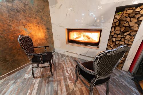 two chairs in a room with a fireplace at Hotel Domenic FREE PARKING in Plovdiv