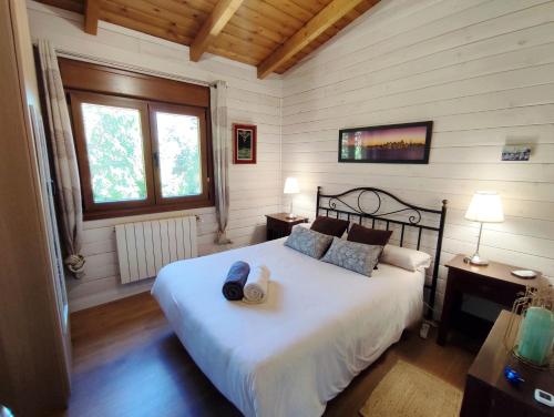 a bedroom with a bed in a room with wooden walls at Preciosa cabaña con jardín y barbacoa in Guadarrama