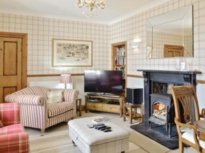 a living room with a fireplace and a tv at Aberdeen Lighthouse Cottages - coastal, dolphins in Aberdeen