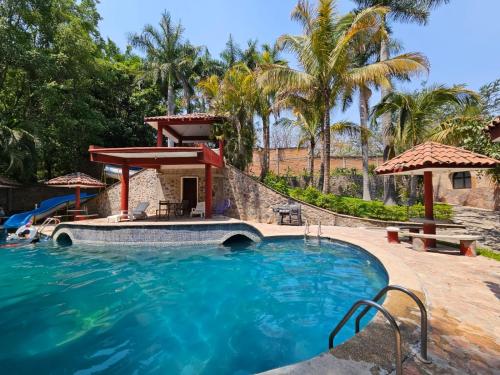 una piscina en un resort con spa y palmeras en Finca Agua Salada, en Xochitepec