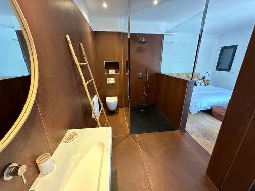 une salle de bain avec un lavabo, un miroir et un lit dans l'établissement Les chambres Marcelle, à Pianottoli-Caldarello