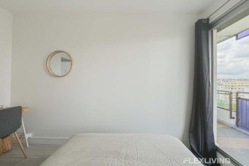 une chambre avec un lit, un miroir et une fenêtre dans l'établissement Flexliving - room - Mouchez, à Paris