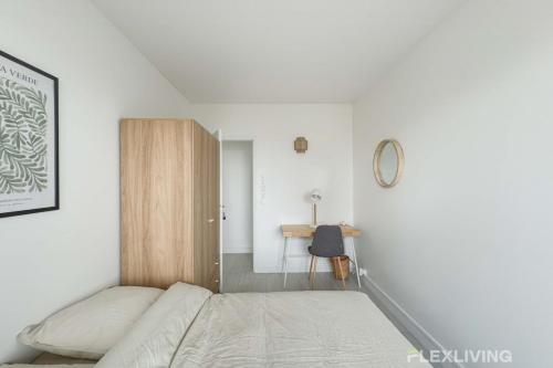 une chambre blanche avec un lit et un bureau dans l'établissement Flexliving - room - Mouchez, à Paris