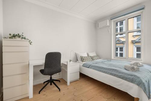 een slaapkamer met een bed, een bureau en een raam bij Charming apartment with stunning views! in Bergen
