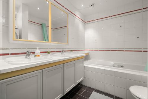 een witte badkamer met 2 wastafels en een bad bij Charming apartment with stunning views! in Bergen