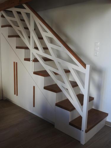 a white staircase with wooden treads in a room at Fabrica House in Mochlos
