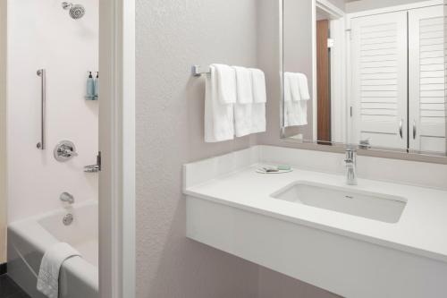 a white bathroom with a sink and a mirror at Courtyard by Marriott Little Rock West in Little Rock