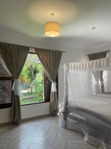 a bedroom with a bed and a large window at Shimoni Reef Lodge in Shimoni