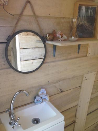 baño con espejo sobre lavamanos en La Cabane, en Prailles