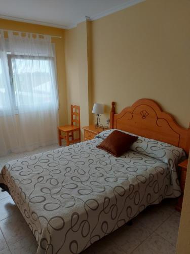 Un dormitorio con una cama grande y una ventana en Vivienda PLAYA DE ALTAR, en Barreiros