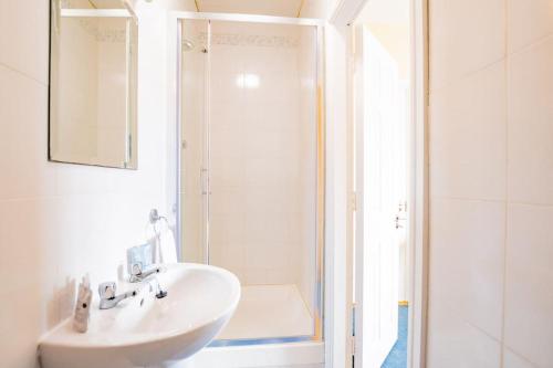 Un baño blanco con lavabo y ducha en 54 - Large Three Bed Apt with Parking, en Galway