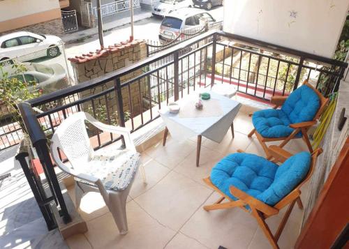 a balcony with chairs and a table on a balcony at Lovely maison house 50m from the beach at Nea Flogita in Flogita