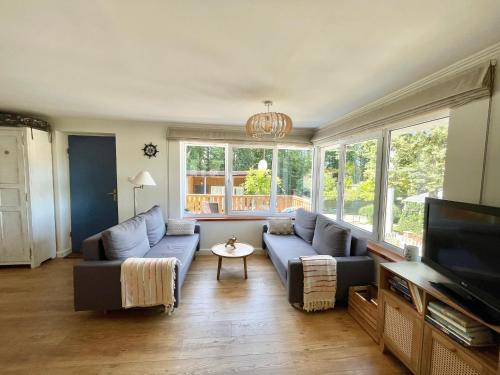 ein Wohnzimmer mit einer blauen Couch und einem Fernseher in der Unterkunft Charzykówka Domek na Kaszubach in Charzykowy