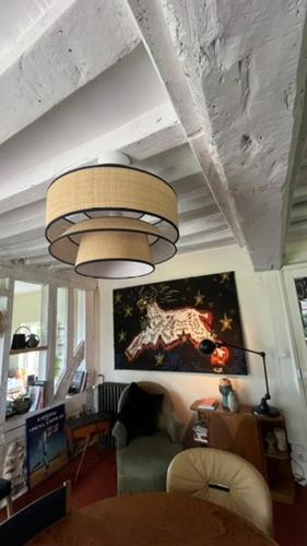 a living room with a chandelier hanging from a ceiling at Gîtes et Spa en Normandie in Sainte-Marguerite-de-Viette