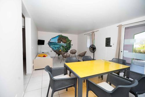 a dining room with a table and chairs at Hôtel Village Pomme Cannelle 3 étoiles in Le Prêcheur