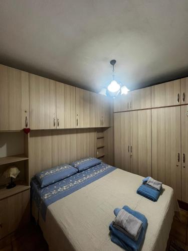una camera da letto con un letto grande con asciugamani blu sopra di Viola's House a Shkodër