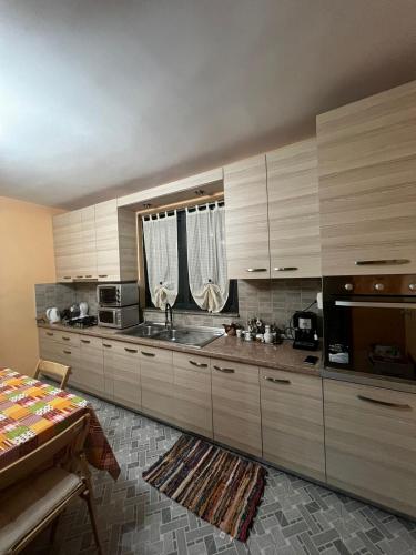 una grande cucina con mobili in legno e un lavandino di Viola's House a Shkodër