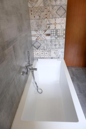 a white bath tub in a bathroom with tiles at B&B vittoria in Bazzano