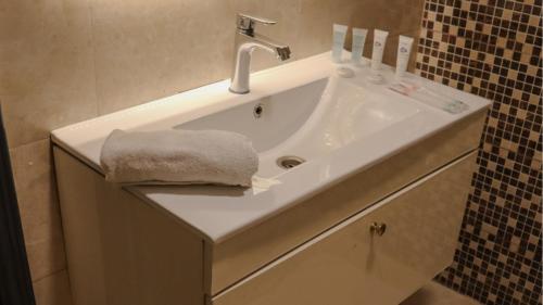 a bathroom with a sink with a towel on it at Sandy palace Hotel in Amman