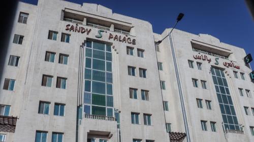 a building with a sign on the side of it at Sandy palace Hotel in Amman