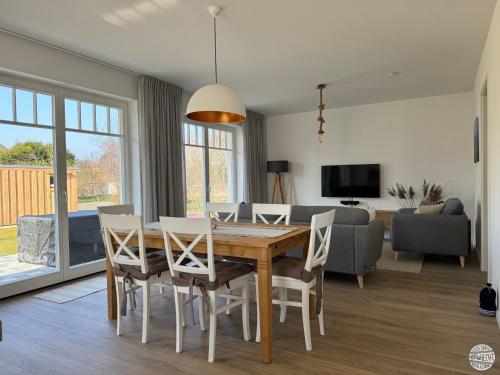 a dining room and living room with a table and chairs at Ferienhaus Hornhecht in Born