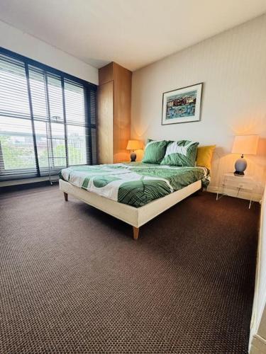 une chambre avec un lit dans une pièce avec des fenêtres dans l'établissement Cosy apt Père Lachaise-Parking privé, à Paris