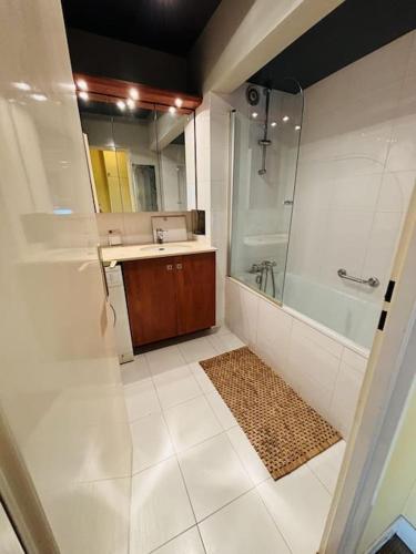 une salle de bain avec un lavabo, une douche et un miroir dans l'établissement Cosy apt Père Lachaise-Parking privé, à Paris