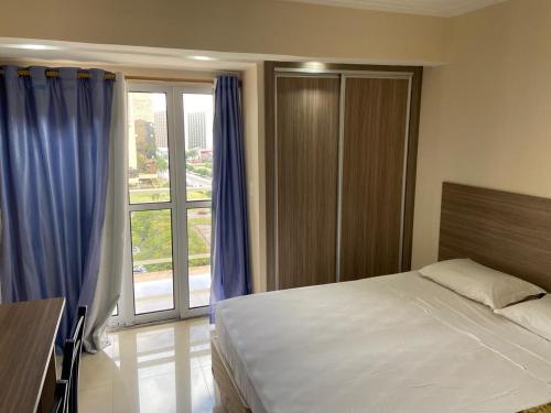 Un dormitorio con una cama y una ventana grande. en Apart Hotel Garvey - Ciany Monteiro, en Brasilia