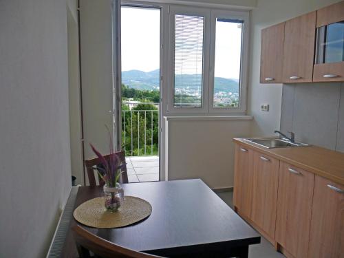 a kitchen with a table and a view of a balcony at Ubytování Stará in Ústí nad Labem