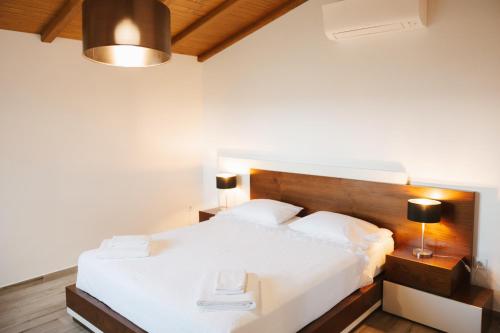 a bedroom with a large white bed with two lamps at Quinta da Malhada in Cabril