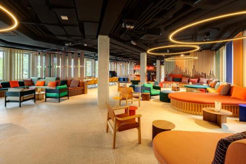 a waiting room with colorful chairs and tables at DEIN APART München in Munich